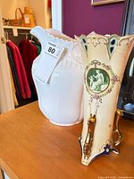 Pitcher and vase side by side on wooden surface