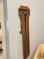 Drying rack folded against wall showing decorative top cap and stacked dowel arms