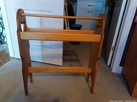 Full view of wooden blanket rack showing heart cutouts and rails