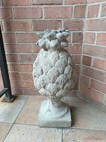Full front view of concrete pineapple ornament showing overall form and scale.