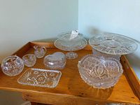 All eight glass and crystal pieces arranged on wooden tray
