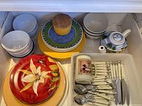Drawer view showing all dishes, teapot, bowls and cutlery tray