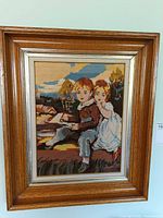 Front view of framed needlepoint showing image and frame