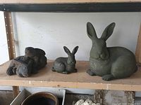 All three cast stone rabbit statues on shelf
