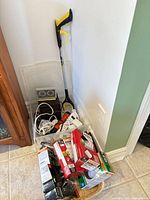 Pile showing grabber, cords, timers, lightbulb boxes, heater rear, basket and tote