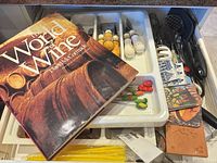 Drawer overview with wine book, utensil tray, cheese spreaders, coasters