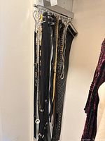 Group of belts hanging on wall rack