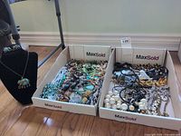 Two trays filled with assorted costume jewelry and elephant necklace set