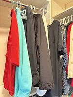 Blouses, dress and pants hanging on closet rod