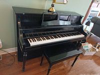 Front view of upright piano with bench