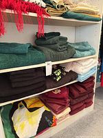 Shelving showing stacks of towels in multiple colours and sizes