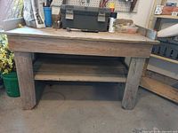 Front view showing full wood workbench with lower shelf and items on top