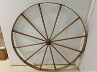 Full wooden wheel leaning against wall