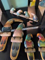 Group shot of all bird carvings showing four wall plaques and mantel display