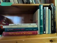 Books stacked horizontally showing titles: The Art of Emily Carr, The Group of Seven, Canadian Art, The Furniture of Old Ontario