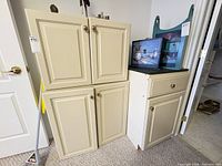 Front view of two stacked cream wall cabinets and white base cabinet