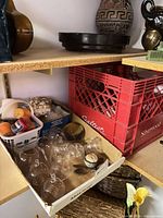 Shelf view showing box of clear glass hanging planters and surrounding items