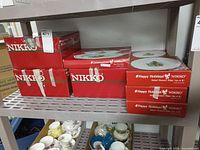 Shelf with six red Nikko Happy Holidays boxes