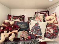 Group shot of all pillows, two bears, and blankets stacked on shelf