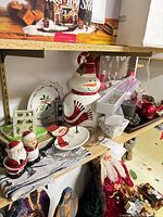 Shelf view showing cookie jar, plates, napkin rings, placemats, shakers
