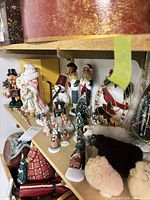 Group of figurines and plush sheep on shelving