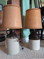 Two stoneware jug lamps with burlap shades side by side