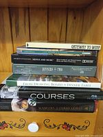 Stack of seven culinary books showing spines