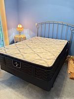 Full view of bed with mattress, box spring, headboard and frame