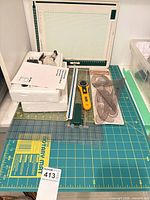 overall view with cutting mat, drawing board, rulers, rotary cutter, French curves