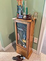 Full lot showing cupboard with items on top and duck decoy on floor