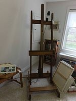 Full view of wooden easel on casters with lamp and measurement scale