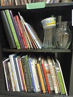 Two shelves of flower arranging books, water stem package and glass vases