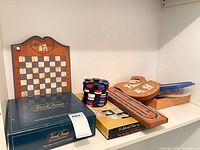 Shelf view showing checkerboard, Trivial Pursuit box, poker chips, cribbage board, card case, wood box