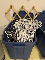 Overall view of tote filled with assorted hangers and wooden peg rack