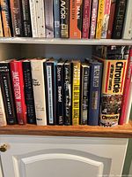 Shelf view showing full lot of hardcover books, two rows visible