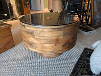 full view of round wooden accent table with glass top