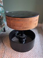 full view of round side table showing glass top, wood collar, cast iron base