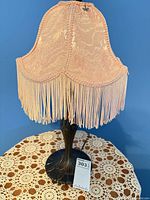 Full view of lamp front showing shade, fringe and base