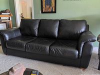 Front view of black leather three-seat sofa