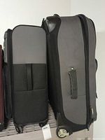 Both suitcases side by side showing relative sizes and wheel types