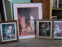 Group shot of four framed prints leaning against wall