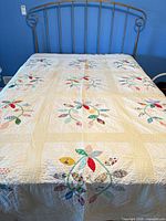 Full view of quilt on bed showing overall pattern and size