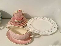 Overview of pink Miniver Rose pieces and two white Rose Buds plates