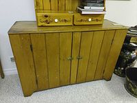 Front view of wooden cabinet showing doors and latches