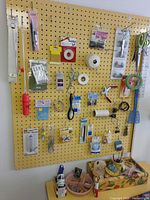 Overall view of pegboard with sewing and crafting items plus desktop accessories