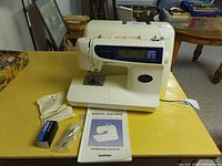 Full view of Brother PC-6000 sewing machine with manual and accessories on table