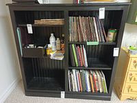 front view of black shelving unit with contents present (not included)