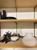 Milk glass bowl with socket, wiring, chain and ribbed globe shade on shelf