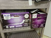 Kirkland pads box (144 count) beside box of 88 underwear