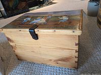 Front angled view of knotty pine chest showing dovetail corners and metal hasp